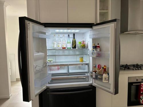 an empty refrigerator with its door open in a kitchen at Family size tropical oasis retreat netflix wifi in Redlynch