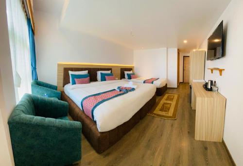 a hotel room with two beds and a chair at Mountain Vista Retreat in Nagarkot