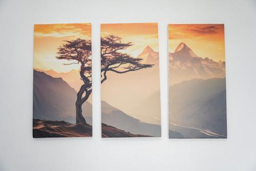 four paintings of a tree in front of mountains at Mountain Vista Retreat in Nagarkot