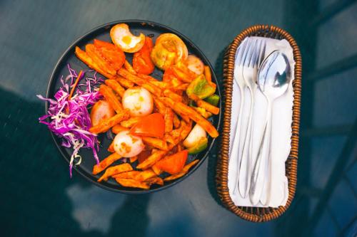 a bowl of carrots and a salad next to a fork at Mountain Vista Retreat in Nagarkot