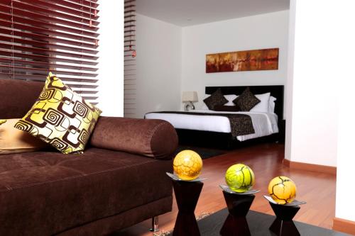 a living room with a couch and a bed at Hotel Suites 108 in Bogotá