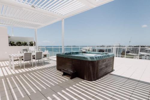 a large room with a hot tub on a balcony at Aquavista Penthouse - Stunning 180 Views in Maroochydore