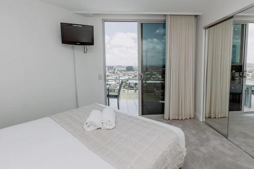 a bedroom with a bed with two towels on it at Aquavista Penthouse - Stunning 180 Views in Maroochydore