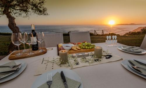 un tavolo con bicchieri da vino e un piatto di cibo di Brenton Breakers a Brenton-on-Sea