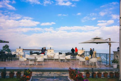 a patio with tables and chairs and an umbrella at Mountain Vista Retreat in Nagarkot