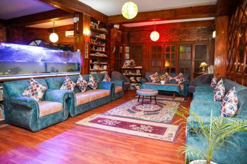 a living room with blue couches and a large aquarium at Mountain Vista Retreat in Nagarkot