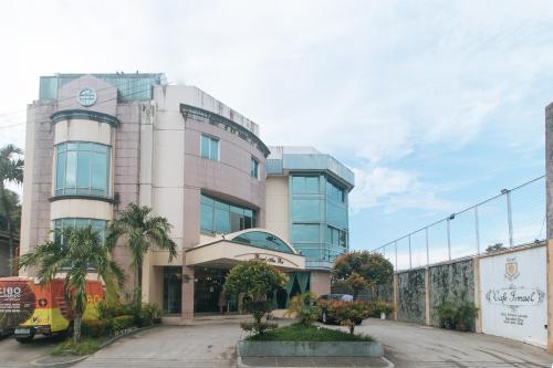 a building with a clock on the side of it at Royal Am Rei Hotel by RedDoorz in Bacolod