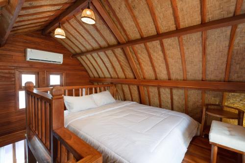 un lit dans une chambre avec un plafond en bois dans l'établissement Luh Adi Villa 3, Modern Balinese wooden house close to Uluwatu, à Uluwatu