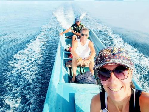 two people sitting on a boat in the water at Indos Homestay-Raja Ampat in Besir