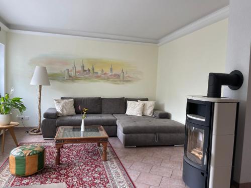 a living room with a couch and a fireplace at Ferienhaus Amare mit Fasssauna, eigener Terrasse & Kamin in Bautzen