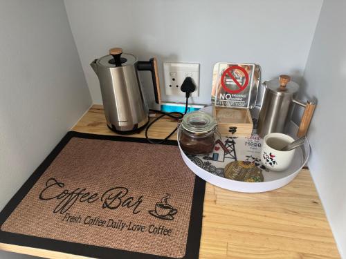 a coffee bar with a cup of coffee and a coffee box at Windpomp Self Catering in Paarl