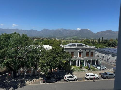 a building with cars parked in a parking lot at Windpomp Self Catering in Paarl