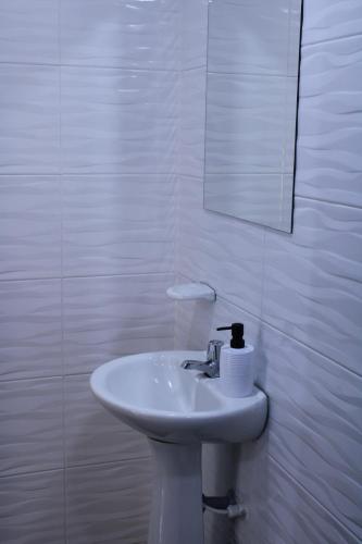 a white bathroom with a sink and a mirror at Casa Esperanza in Cali