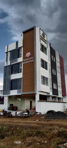 a building with a motorcycle parked in front of it at Nandini Executive Lodge in Tuljapur