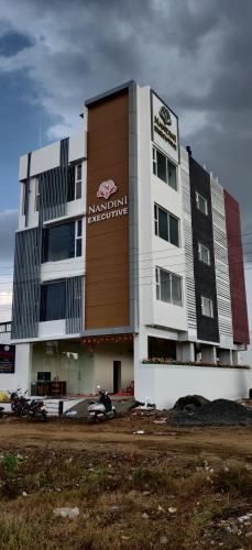 a building with a sign on the side of it at Nandini Executive Lodge in Tuljapur