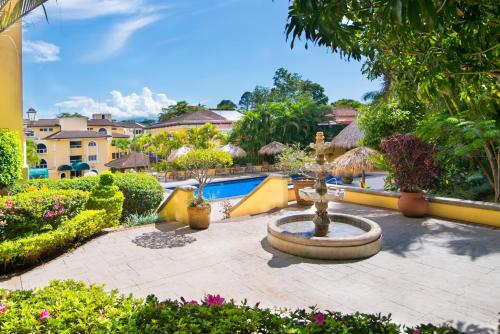a courtyard with a fountain and a swimming pool at Apartotel & Suites Villas del Rio in San José