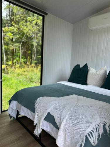 a bedroom with a bed and a large window at The Dacious by Tiny Away in Midgenoo