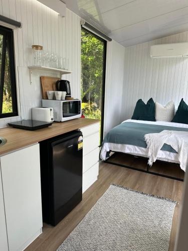 a bedroom with a bed and a microwave on a counter at The Dacious by Tiny Away in Midgenoo