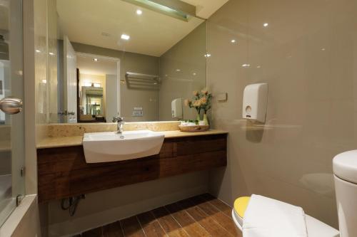 a bathroom with a sink and a mirror at Le Charcoa Hotel in Chiang Mai