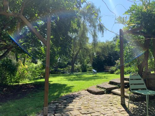 a green bench sitting on a stone path in a park at Chez Cedric & Emmanuelle in Plonéour-Lanvern