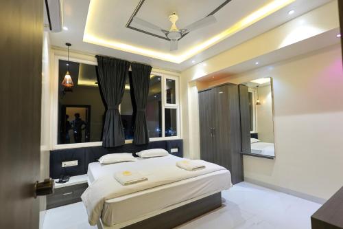 a bedroom with a large bed and a mirror at Nandini Executive Lodge in Tuljapur