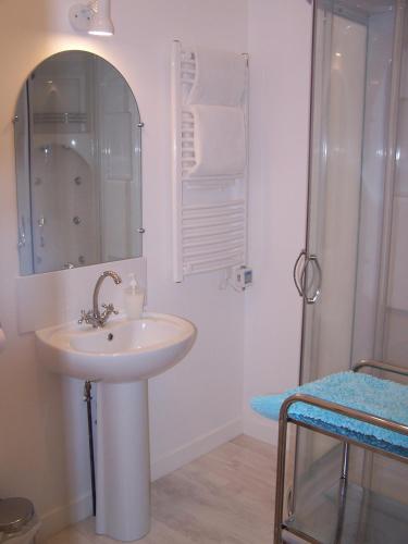 une salle de bain blanche avec un lavabo et une douche dans l'établissement Le Four à Pain, à Saint-Jean-dʼAngély