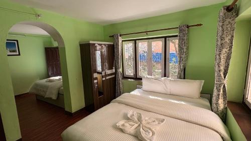a green room with two beds and a window at Wander Thirst in Kathmandu