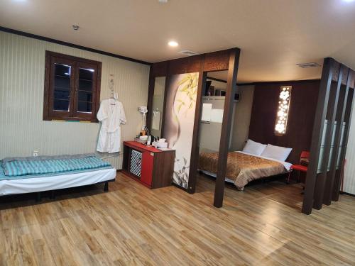 a bedroom with two beds and a mirror at Daebudo Hue Motel in Ansan