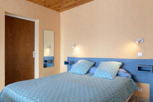 a bedroom with a blue bed with blue pillows at Résidence Amaréna in Saint-Paul-lès-Dax
