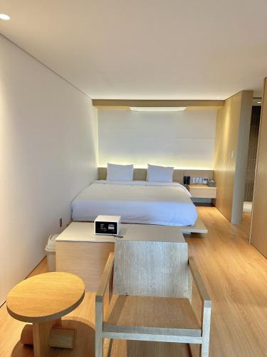 a bedroom with a large bed and a table at Hotel SANG SANG & Private SANG SANG POOL VILLA in Geoje 