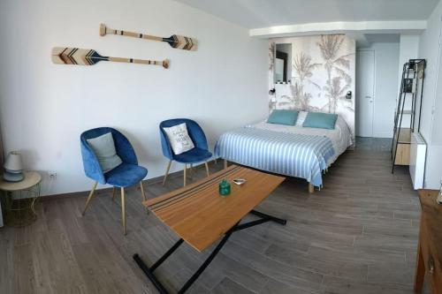 - une chambre avec deux chaises bleues et un lit dans l'établissement Sea Lodge - Plage de Port Mer, Cancale, à Cancale