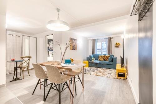 une salle à manger et un salon avec une table et des chaises dans l'établissement Sweett- Aboukir I, à Paris