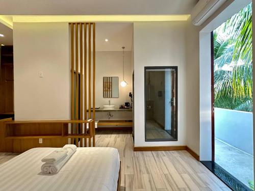 a bedroom with a bed and a bathroom with a mirror at The R&B Boutique in Kampot