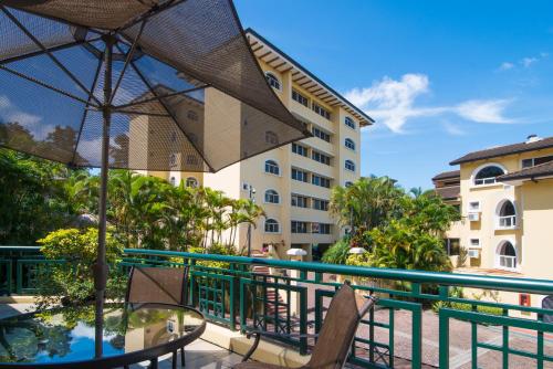 a balcony with a table and chairs and a building at Apartotel & Suites Villas del Rio in San José