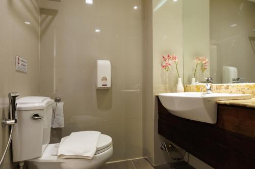 a bathroom with a white toilet and a sink at Le Charcoa Hotel in Chiang Mai