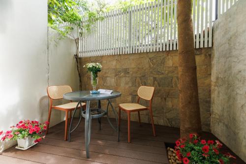 a small table and chairs on a patio at Le Charcoa Hotel in Chiang Mai