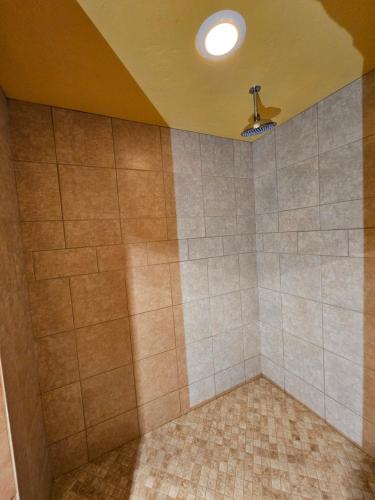 a tiled shower with a ceiling fan in a room at Chanticleer Cabins in Sturgeon Bay