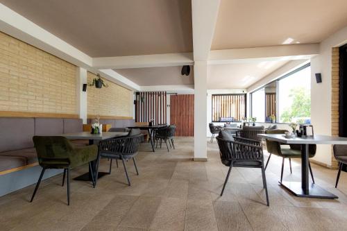 a dining room with tables and chairs and windows at RUTA 85 Hotel Restaurant in Iugani