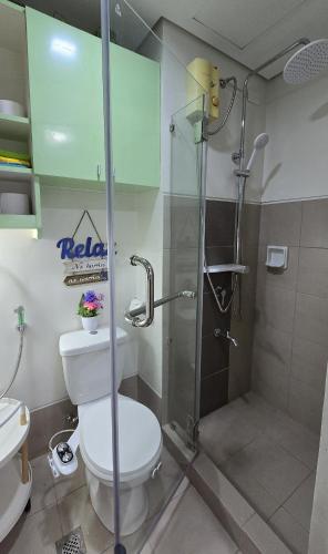 a bathroom with a toilet and a glass shower at SMDC Spring Resort Residences in Manila