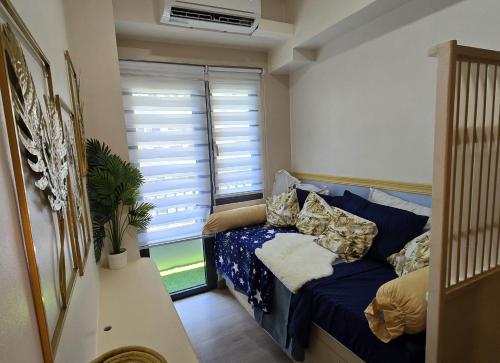 a small room with a blue couch and a window at SMDC Spring Resort Residences in Manila