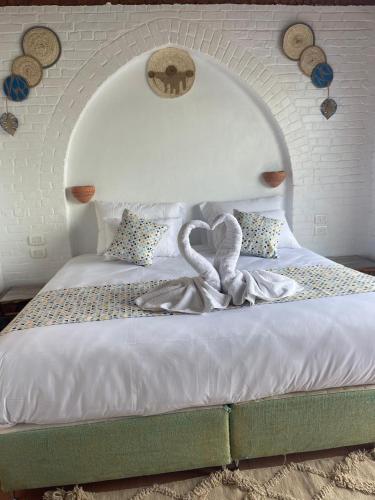 a bed with a swan decoration on top of it at Dolty Kato Nubian House By Kato Dool in Aswan