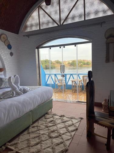 a bedroom with a bed and a view of the water at Dolty Kato Nubian House By Kato Dool in Aswan