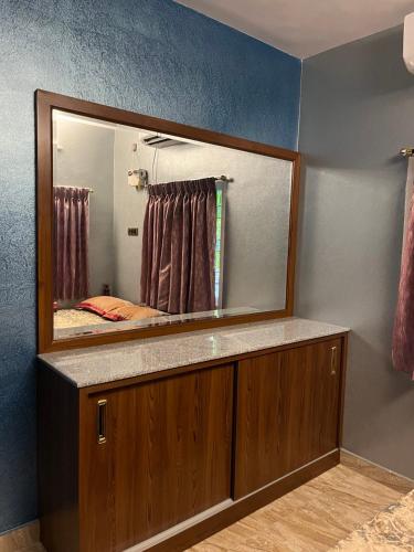 a bathroom with a large mirror on a counter at Seaside Serenity in Mahabalipuram