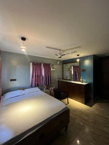 a bedroom with a bed and a desk and a mirror at Seaside Serenity in Mahabalipuram