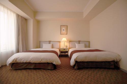 Postel nebo postele na pokoji v ubytování Miyako Hotel Yokkaichi