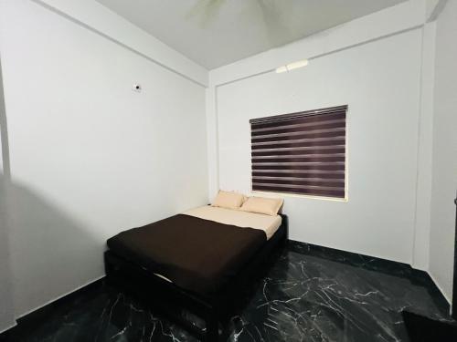 a small bedroom with a bed and a window at Nest Homes in Nilambūr