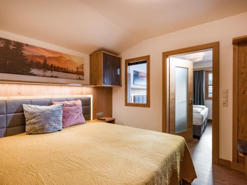 a bedroom with a bed with a yellow bedspread at Hotel Kroneck in Kirchberg in Tirol