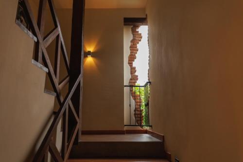 a stairway with a brick wall and a window at Le Charcoa Hotel in Chiang Mai