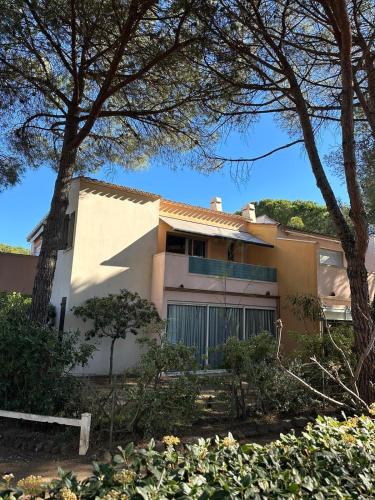 une maison blanche avec des arbres devant dans l'établissement Résidence Euréka H137, au Cap d'Agde