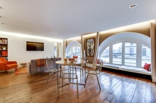 une salle à manger avec une table et des chaises et un salon dans l'établissement Sweett - Amiral de Coligny, à Paris